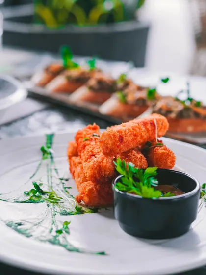 A platter of crispy fried cheese sticks, a perfect appetizer to kickstart your meal.