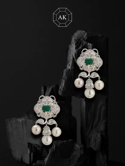Soft sparkle, strong statement. These earrings bring together rich emeralds, various diamond cuts, and South Sea pearls in 18K gold.