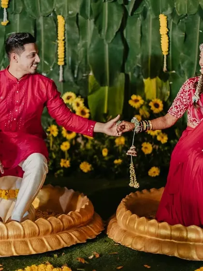 A sweet portrait of the couple seated in decorative golden bowls, a unique setup for a Haldi ceremony.