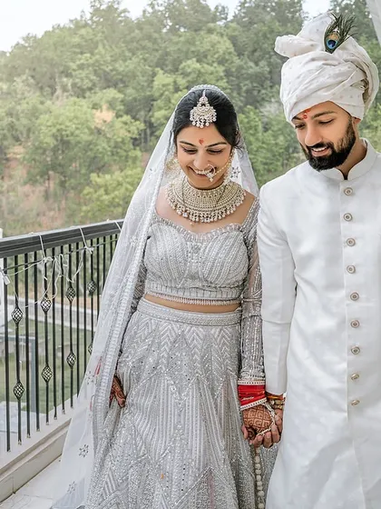 A happy, candid moment as the newly married couple walks along the balcony of their resort, with the beautiful Rishikesh landscape behind them.