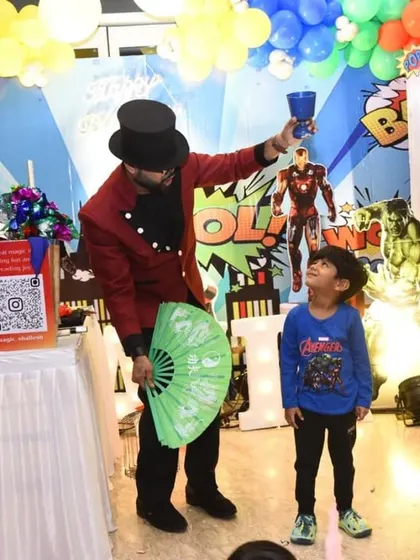 The birthday boy is fascinated as I perform a classic cup and ball illusion right in front of him. Getting kids involved up close makes the magic even more real for them.