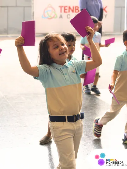 A child joyfully participates in a drill, waving a card with enthusiasm.
