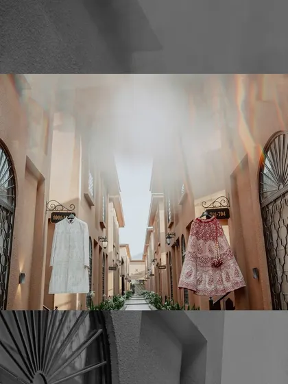 A creative shot showcasing the couple's wedding outfits. Hanging the lehenga and sherwani in this beautiful alleyway creates an artistic and visually interesting photograph.