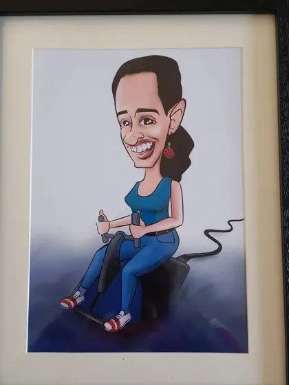 A framed digital caricature of a woman on a stationary bike. A great gift for a fitness enthusiast.