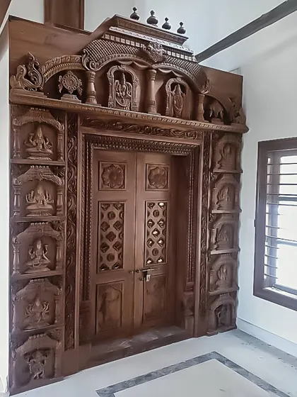 Another example of a stunning, hand-carved wooden pooja room entrance. The level of detail in the carvings of deities and traditional motifs is simply breathtaking.