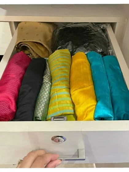 A drawer filled with neatly file-folded sarees. This is a great way to store sarees that you wear often, as it keeps them visible and accessible without taking up hanging space.