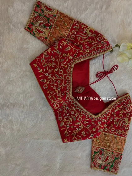 The front view of the red blouse, with delicate gold floral embroidery.