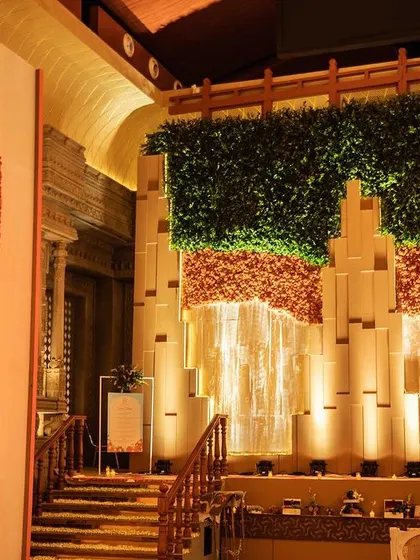 A jharokha-style window on the side wall, completely layered with hand-pasted orange chrysanthemums, bringing texture and vibrant color to the space.