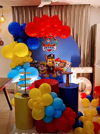 We assembled the whole Paw Patrol team for Agastya's 5th birthday. This setup features a character backdrop, themed pedestals in primary colours, and a large light-up number "5" for the birthday boy.