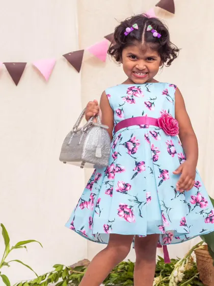 Accessorizing in style. This light blue dress with a bold pink floral print is paired with a sparkly silver handbag, showing how easy it is to dress up my everyday frocks.