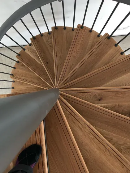 The precise fit of each oak tread against the central steel pole is critical in a spiral design. This top-down view shows the craftsmanship involved.