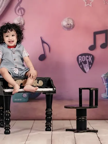 This little rockstar is ready to perform! Our music-themed studio setup includes a mini piano, drums, and a gramophone.