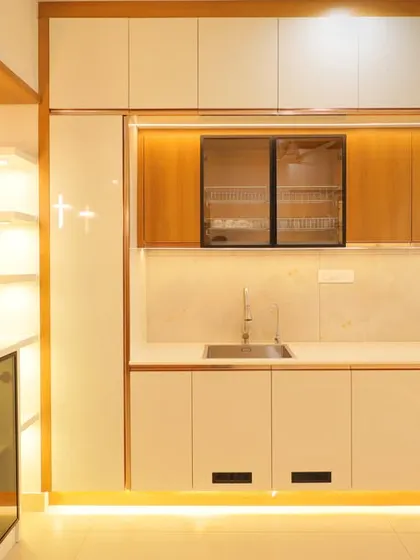 A closer look at the clean lines and seamless integration of this white and wood kitchen. The under-cabinet and toe-kick lighting adds a warm and modern touch.