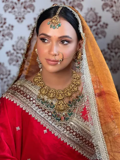 A close-up of the bride's regal look, her hair perfectly styled to showcase her stunning temple jewelry.