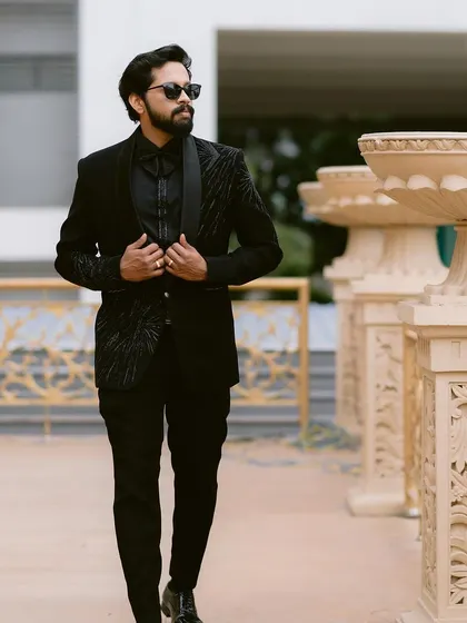 A groom looking sharp and stylish in a modern black suit. We capture these portraits to showcase the groom's personality and style on his wedding day.