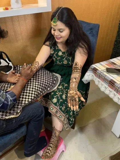 A behind-the-scenes look at a full bridal mehndi session. You can see me applying the design while the bride relaxes, showcasing the home service I provide.