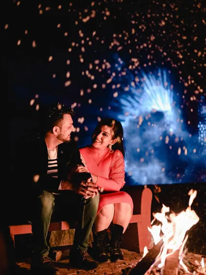 The bonfire setup provides a warm, intimate light that's perfect for capturing loving glances and heartfelt connections.