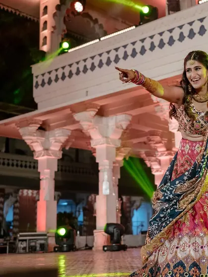 A wide shot of Sneha on the dance floor, showing off the beautiful flare and colors of her Mayyur Girotra lehenga. A perfect outfit for a sangeet performance.