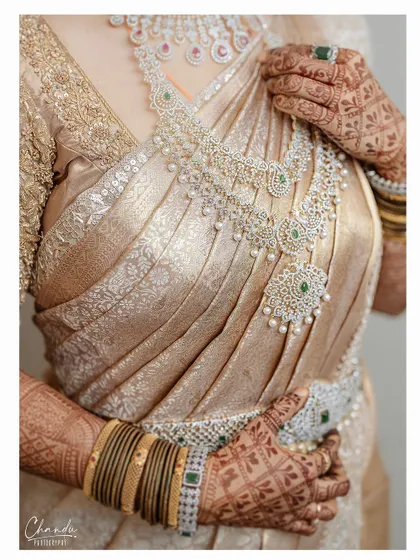 A detailed shot of the stunning diamond jewelry against the rich texture of the Kanjeevaram saree. The makeup look was designed to complement these luxurious details.