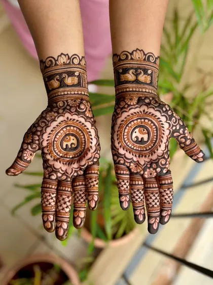 A lovely engagement design with a central elephant mandala on the palm, surrounded by delicate details and swan motifs on the wrist.