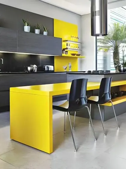 A bold and contemporary kitchen with a bright yellow dining extension attached to the island. The contrast with the dark grey cabinets creates a vibrant, energetic space.