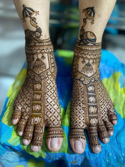 This unique design features a peacock on an elephant at the ankle, with lotus and geometric patterns covering the rest of the foot.