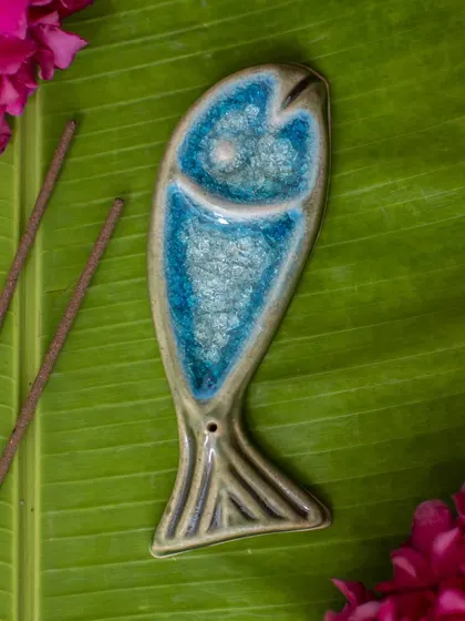 This fish-shaped ceramic incense holder is a true work of art. This version features a stunning blue crystalline crackle glaze that is simply mesmerizing. It's a beautiful and functional piece for your coffee table or pooja space.