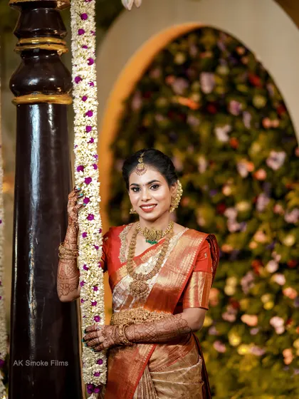 A lovely portrait of the bride by a pillar, with a beautifully decorated floral background.