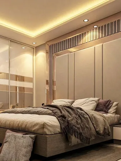 This modern bedroom uses mirrors to create a sense of spaciousness. A tall, upholstered headboard is flanked by full-length mirrors, which reflect the light from the ceiling and create a bright, expansive feel.