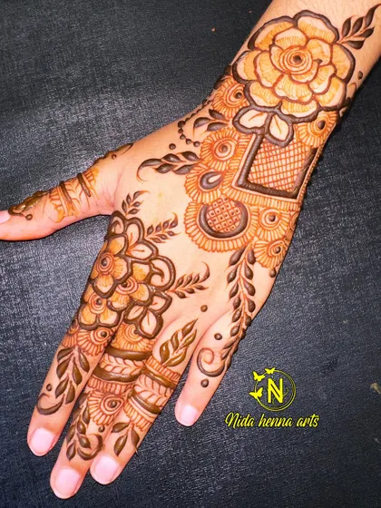 An elegant floral design perfect for Eid celebrations. This style combines bold flowers with delicate leaves and net patterns, creating a beautiful look for the back of the hand.