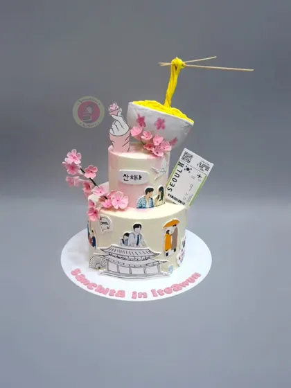 A creative K-drama themed cake featuring an anti-gravity noodle bowl, cherry blossoms, and scenes from "Itaewon Class".