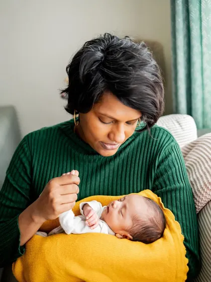 A mother admiring her newborn's tiny features. These quiet, intimate moments are what make at-home sessions so special.