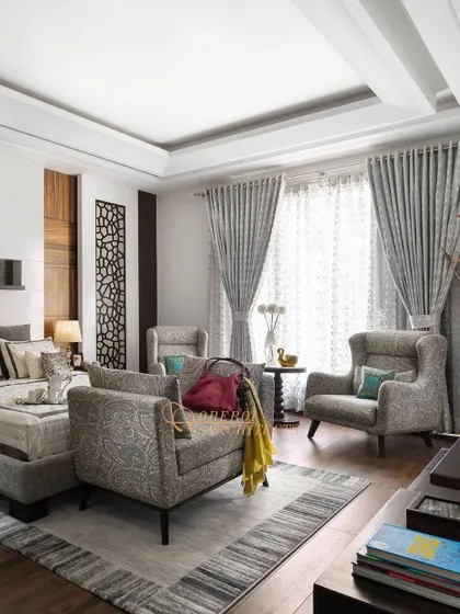 Another view of the grey-toned bedroom, highlighting the comfortable seating area with wingback chairs, perfect for a quiet morning coffee.