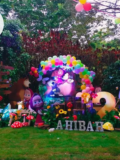 A wide view of the Masha and the Bear setup in a lush garden. The arrangement includes Masha, the Bear, the penguin, and the panda, creating a full character scene.
