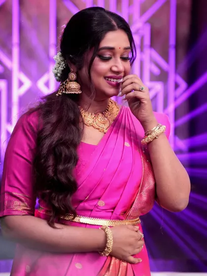 A candid, happy shot of singer Antara Mitra in a traditional pink silk saree.