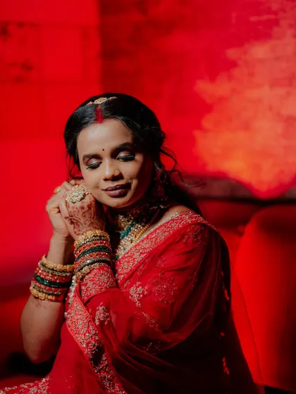 An artistic portrait of the bride with her eyes closed, captured with dramatic red lighting.