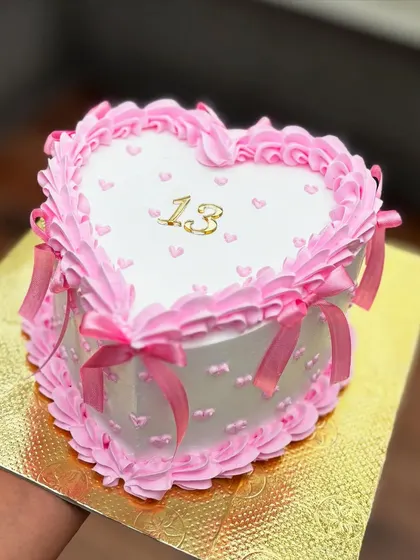 A sweet vintage-style heart cake for a 13th birthday. The delicate pink ruffles and satin bows give it a very coquette, romantic feel.
