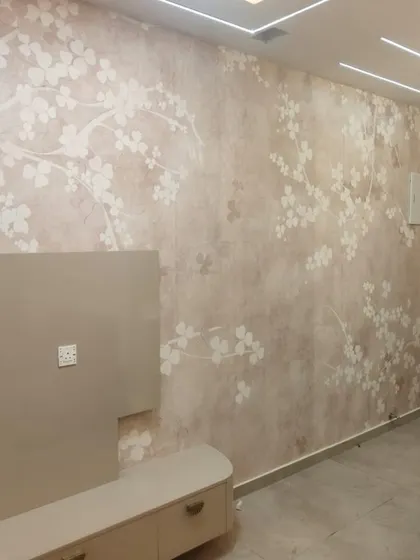 This living room features a large-scale cherry blossom wallpaper in soft, neutral tones. The elegant design creates a serene and sophisticated atmosphere, perfect for a relaxing space.