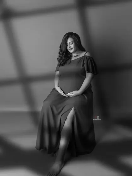 A moody and artistic black and white portrait using shadows for a dramatic effect. This style is perfect for creating a thoughtful and introspective maternity photo.