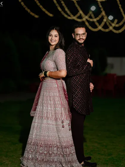 A full-length shot of the couple, showcasing the beautiful flow of the bride's lehenga.