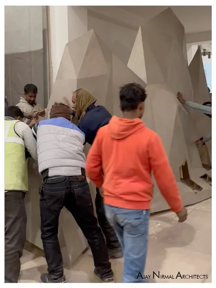 Our team carefully assembles the abstract, faceted backdrop for the Pllum Legno art installation. This image shows the hands-on work required to bring complex geometric designs to life.