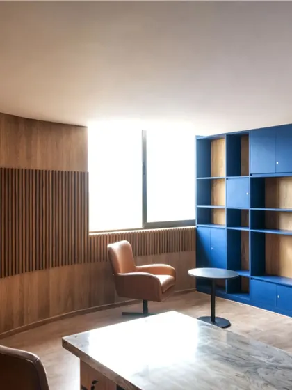 An interior view of an office space at MSAP, where wood paneling and a bold blue shelving unit create a functional yet aesthetically refined environment. This demonstrates our attention to detail within larger institutional projects.
