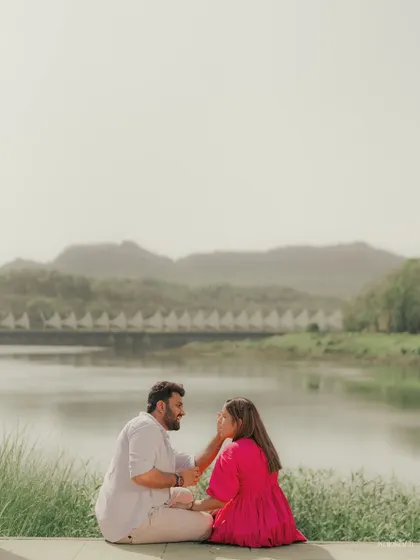 A quiet, intimate moment sitting by the water's edge, lost in their own world.