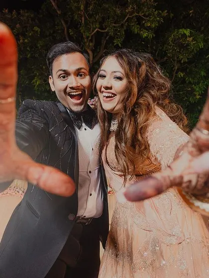 A fun, wide-angle shot that feels like a selfie with the couple. Their joyful expressions and outstretched hands create a sense of energy and adventure, perfectly capturing their personalities.