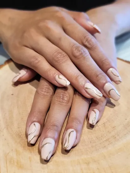 Chrome love, but make it subtle. This design features delicate gold chrome swirls over a matte nude base for a sophisticated and modern look.