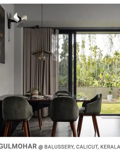 A view across the dining area to the living room in Gulmohar, demonstrating the open layout and constant visual connection to the lush exterior.