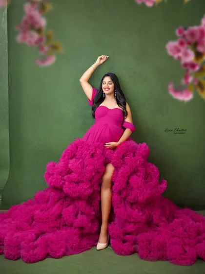 A fun, celebratory pose that shows off the incredible volume and movement of this pink ruffled gown. It’s a dress that’s made for dancing and smiling.