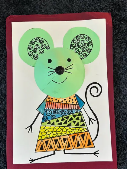 A cool green mouse with some very intricate zentangle-like patterns on its dress.