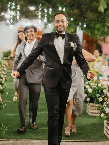 The groom makes a grand, energetic entrance to the reception, leading his entourage in a dance down the aisle.