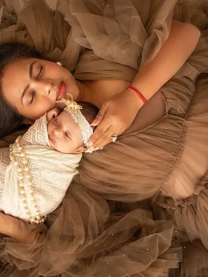 A mother rests with her newborn in a sea of beautiful brown tulle. An artistic and loving mother-and-child portrait.